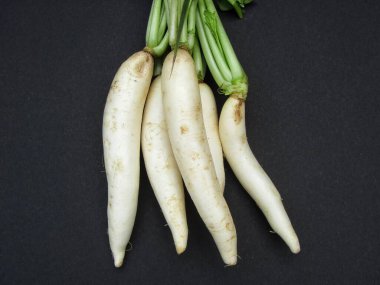 White radish or mooli on black background 