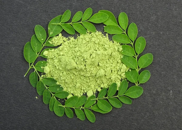 Moringa oleifera powder on a black background 