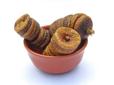 Beyaz arka planda bir kasede kurutulmuş incir meyvesi. 