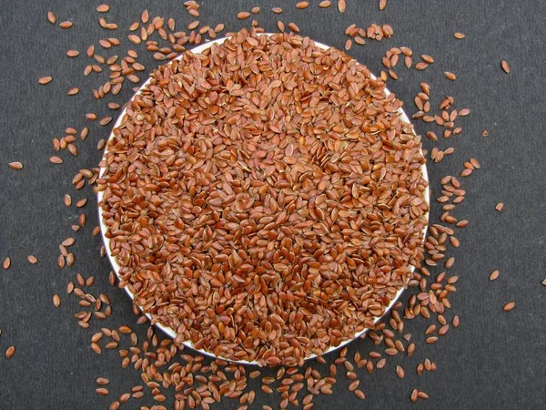 Siyah arkaplan görünümlü bir tabakta keten tohumları 