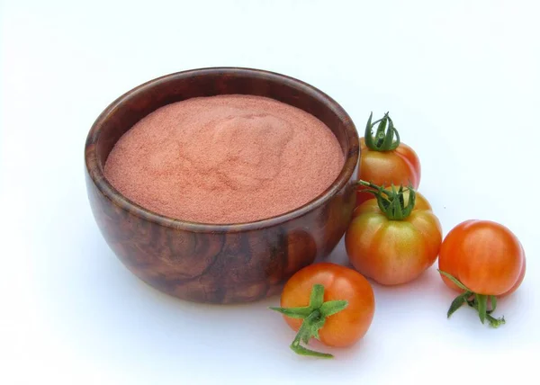Beyaz arka planda ahşap bir kasede domates tozu 