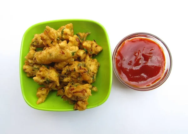 Hint atıştırmalıkları Pakora, beyaz arka planda domates ketçapı. 