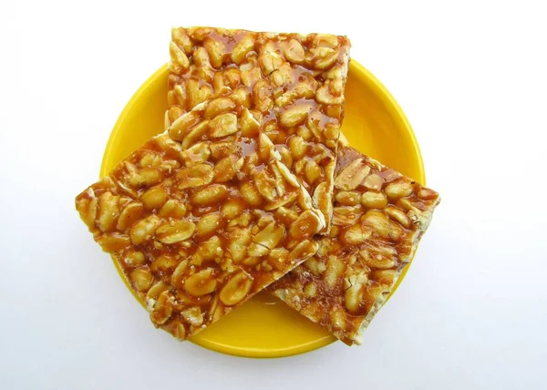 Beyaz arkaplanda bir tabakta fıstık chikki çubuğu 