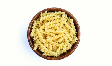 Beyaz arka planda ahşap bir kasede Fusilli makarna 