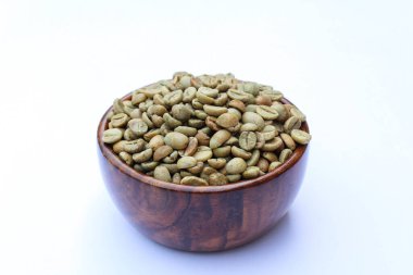 Beyaz arka planda ahşap bir kasede yeşil kahve çekirdekleri. 