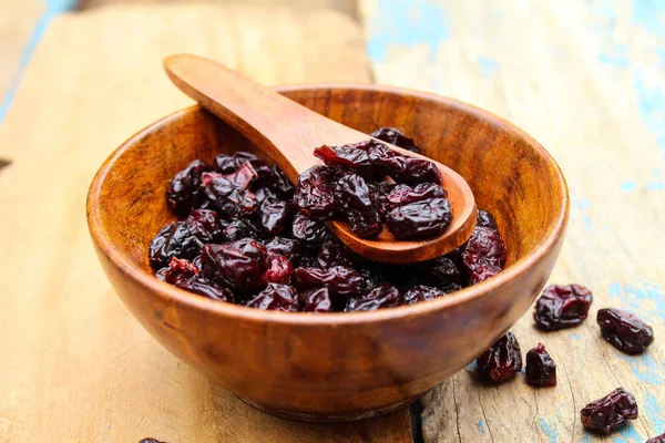 Kurutulmuş kızılcık, ahşap bir kasede, kaşık yakın görüşlü. 