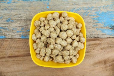 Soya, ahşap arka planda bir kasede parçalar halinde duruyor. 