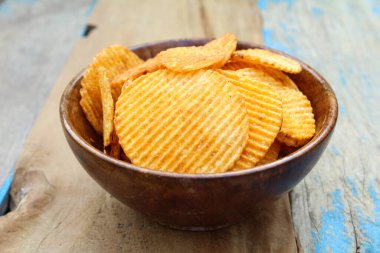 Tahta kasenin yanında patates cipsi. 