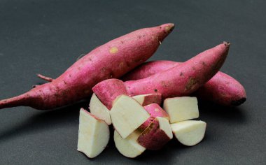 Tatlı patatesler siyah arka planda yakın plan görüntüde dilimlenmiş. 