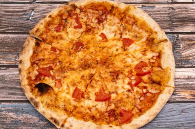 Köy ahşap arka planda erimiş peynirli sıcak pizza. Ev yapımı pizza yemek için hazır. İtalyan yemeği..