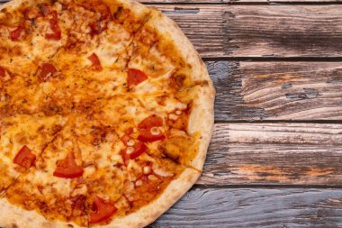 Köy ahşap arka planda erimiş peynirli sıcak pizza. Ev yapımı pizza yemek için hazır. İtalyan yemeği..