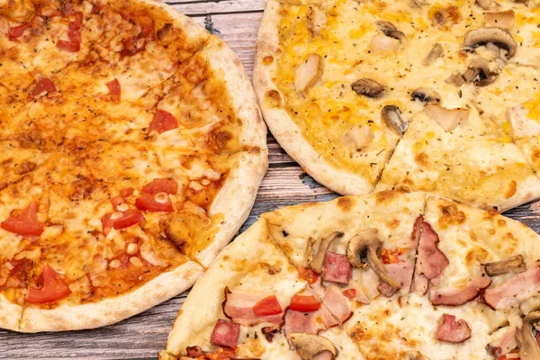 Köy ahşap arka planda erimiş peynirli sıcak pizza. Ev yapımı pizza yemek için hazır. İtalyan yemeği..