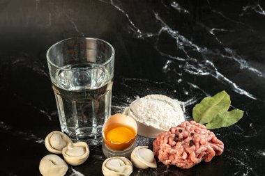 Koyu arkaplanda etli börek yapmak için gerekli malzemeler, yakın plan