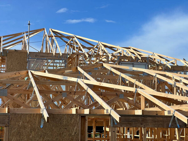 New residential construction home framing against a blue sky. High quality photo