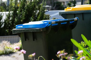 Avustralya 'nın banliyösündeki arka bahçeye yerel konseyin sağladığı çöp bidonları. Yüksek kalite fotoğraf