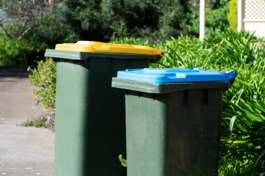 Avustralya 'nın banliyösündeki arka bahçeye yerel konseyin sağladığı çöp bidonları. Yüksek kalite fotoğraf