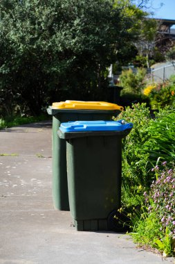 Avustralya 'nın banliyösündeki arka bahçeye yerel konseyin sağladığı çöp bidonları. Yüksek kalite fotoğraf