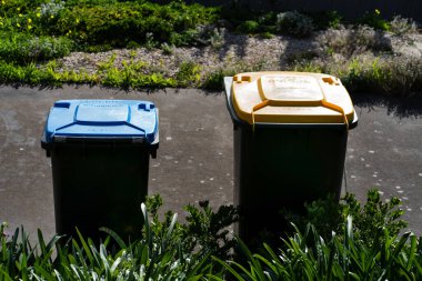 Avustralya 'nın banliyösündeki arka bahçeye yerel konseyin sağladığı çöp bidonları. Yüksek kalite fotoğraf