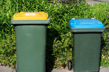 Avustralya 'nın banliyösündeki arka bahçeye yerel konseyin sağladığı çöp bidonları. Yüksek kalite fotoğraf