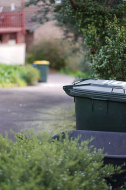 Avustralya 'nın banliyösündeki arka bahçeye yerel konseyin sağladığı çöp bidonları. Yüksek kalite fotoğraf