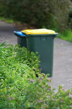 Avustralya 'nın banliyösündeki arka bahçeye yerel konseyin sağladığı çöp bidonları. Yüksek kalite fotoğraf