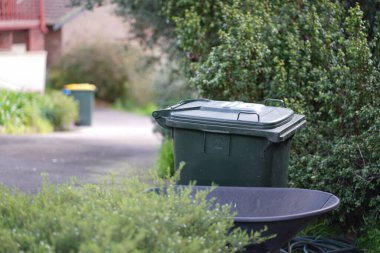 Avustralya 'nın banliyösündeki arka bahçeye yerel konseyin sağladığı çöp bidonları. Yüksek kalite fotoğraf