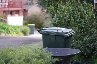 Avustralya 'nın banliyösündeki arka bahçeye yerel konseyin sağladığı çöp bidonları. Yüksek kalite fotoğraf