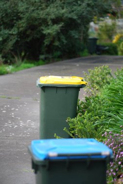 Avustralya 'nın banliyösündeki arka bahçeye yerel konseyin sağladığı çöp bidonları. Yüksek kalite fotoğraf