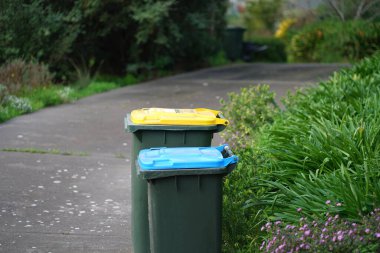 Avustralya 'nın banliyösündeki arka bahçeye yerel konseyin sağladığı çöp bidonları. Yüksek kalite fotoğraf