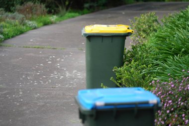 Avustralya 'nın banliyösündeki arka bahçeye yerel konseyin sağladığı çöp bidonları. Yüksek kalite fotoğraf