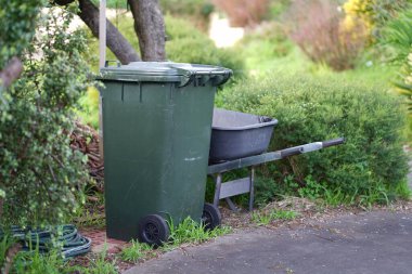 Avustralya 'nın banliyösündeki arka bahçeye yerel konseyin sağladığı çöp bidonları. Yüksek kalite fotoğraf