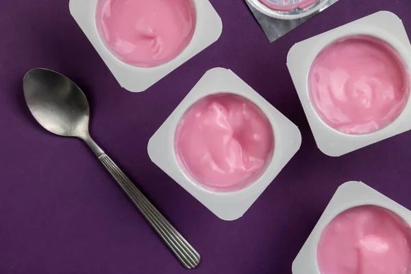 Fruit Gearomatiseerde Yoghurt Witte Plastic Bekers Heldere Paarse Achtergrond Met — Stockfoto
