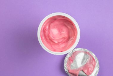 Pembe yoğurt fincanı - eflatun arkaplanlı çilekli yoğurt üst görünümü metin için boşluk