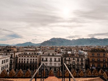 A bird-eye view at Palermo historic centre from the rooftop of Palermo Cathedral. Hills are visible in the horizon. Ancient architecture of the city. And blue sea near.