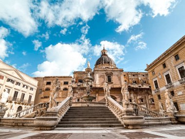 Ancient church of Palermo photographed from the bottom up. A palm tree nearby is as tall as the church tower.