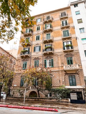 Narrow streets on the old town of Palermo in Sicily, Italy. Gorgeous architecture in the sunshine. Scooters are parked near the walls, and greenery is in the pots.