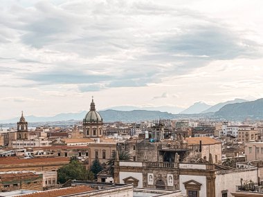 A bird-eye view at Palermo historic centre from the rooftop of Palermo Cathedral. Hills are visible in the horizon. Ancient architecture of the city. And blue sea near.