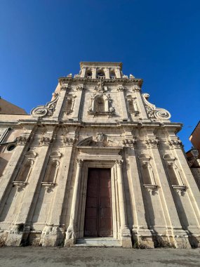Narrow streets on the old town of Syracuse in Sicily, Italy. Gorgeous architecture in the sunshine. Scooters are parked near the walls, and greenery is in the pots.
