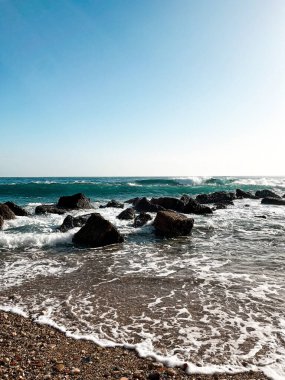 Turquoise water of the Mediterranean Sea near the shore of Italy. Beautiful colour of the calm waters, rocks far away near the horizons - perfect spot for relaxation.