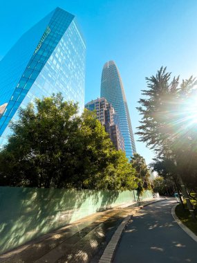 San Francisco 'nun cam ve beton gökdelenleri tepeden tırnağa görünüyor. Güneşli bir günde dev bina ışıldıyor, yollar az trafikle kesişiyor..
