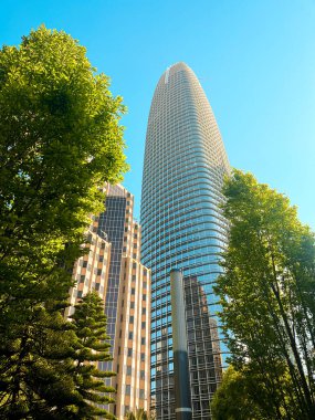 San Francisco 'nun cam ve beton gökdelenleri tepeden tırnağa görünüyor. Güneşli bir günde dev bina ışıldıyor, yollar az trafikle kesişiyor..