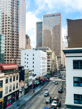 San Francisco 'nun cam ve beton gökdelenleri tepeden tırnağa görünüyor. Güneşli bir günde dev bina ışıldıyor, yollar az trafikle kesişiyor..