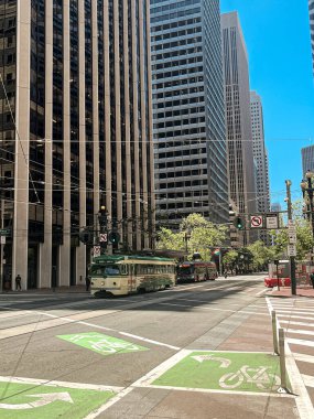 San Francisco caddesindeki tramvay. Şehrin dik tepelerini aşmak için güzel bir ulaşım fırsatı. Tramvay rayları güneşte parlıyor. Ağaçlı sokaklar.