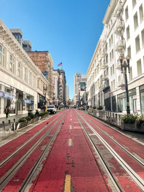 San Francisco caddesindeki tramvay. Şehrin dik tepelerini aşmak için güzel bir ulaşım fırsatı. Tramvay rayları güneşte parlıyor. Ağaçlı sokaklar.