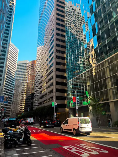 San Francisco 'nun cam ve beton gökdelenleri tepeden tırnağa görünüyor. Güneşli bir günde dev bina ışıldıyor, yollar az trafikle kesişiyor..