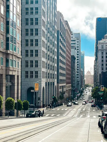 San Francisco 'nun cam ve beton gökdelenleri tepeden tırnağa görünüyor. Güneşli bir günde dev bina ışıldıyor, yollar az trafikle kesişiyor..