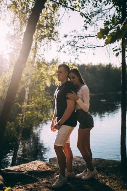 Güzel, genç ve sevgi dolu bir çift nehir kenarında kucaklaşıyor..       