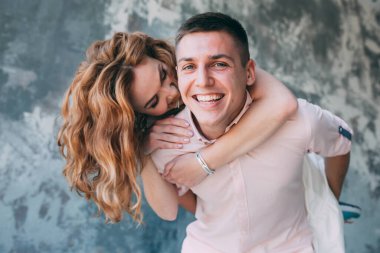 Mutlu genç çift, birlikte poz veriyor ve stüdyoda sarılıyorlar.                    