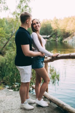 Güzel, genç ve sevgi dolu bir çift nehir kenarında kucaklaşıyor..       