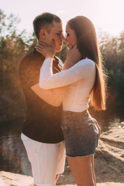 Güzel, genç ve sevgi dolu bir çift nehir kenarında kucaklaşıyor..       